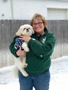 A woman holding a dog in her arms.