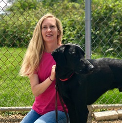 A woman and her dog are posing for the camera.