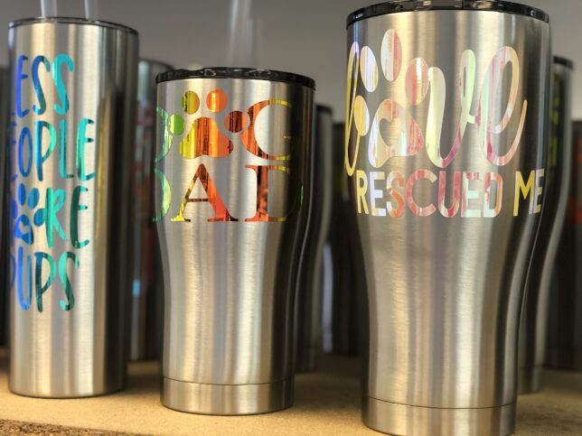 A close up of three cups on a shelf