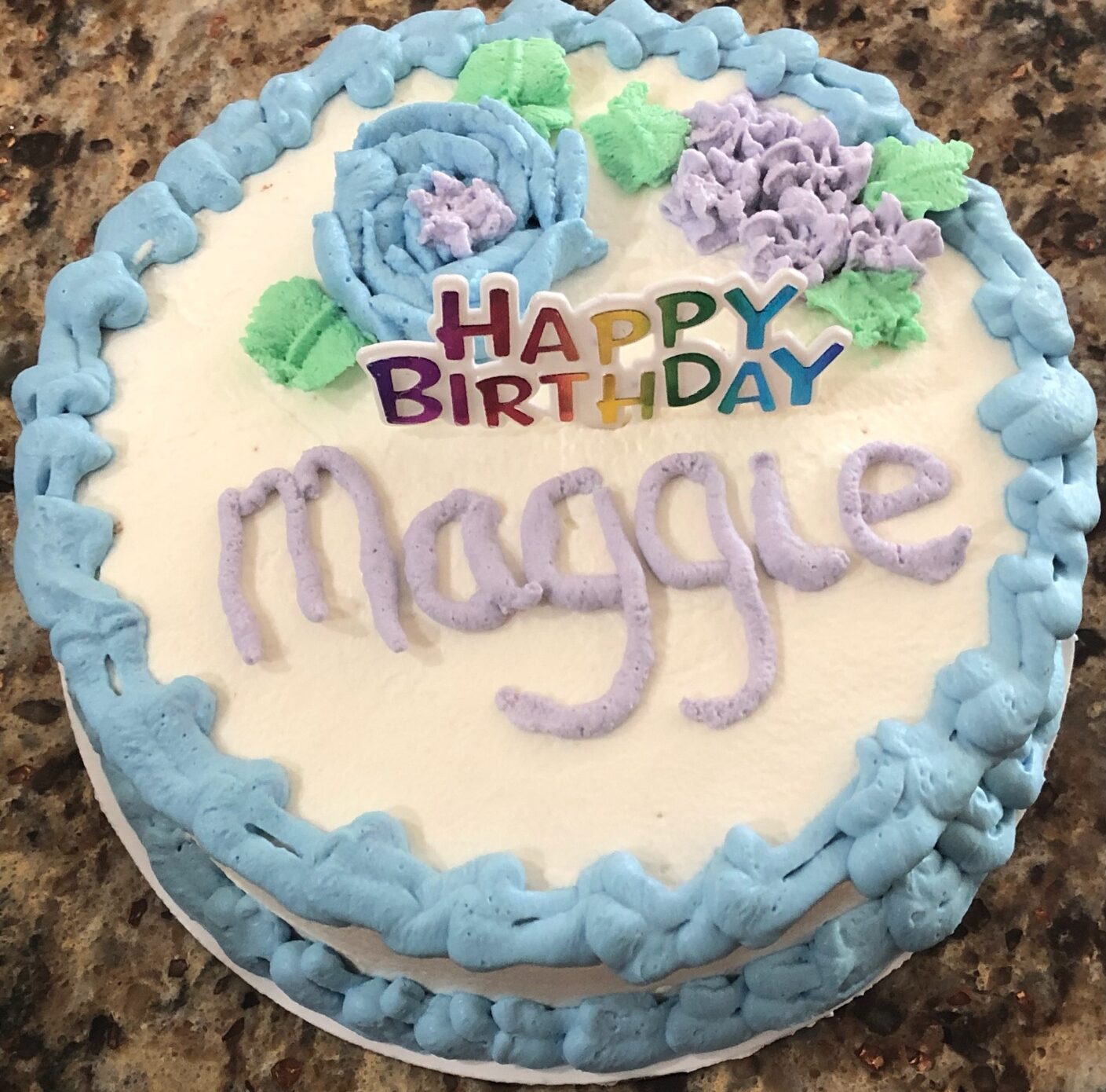 A birthday cake with the name maggie on it.