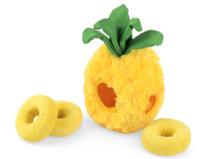 A pineapple toy next to two rings of fruit.