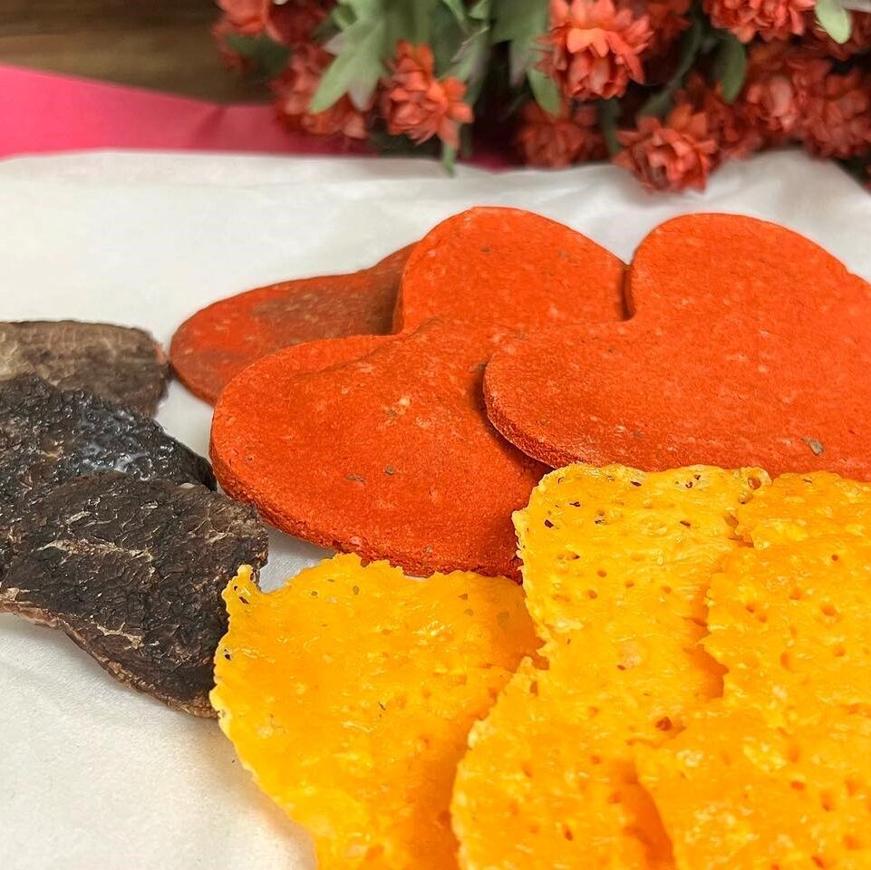 A plate of food with orange and red cookies.