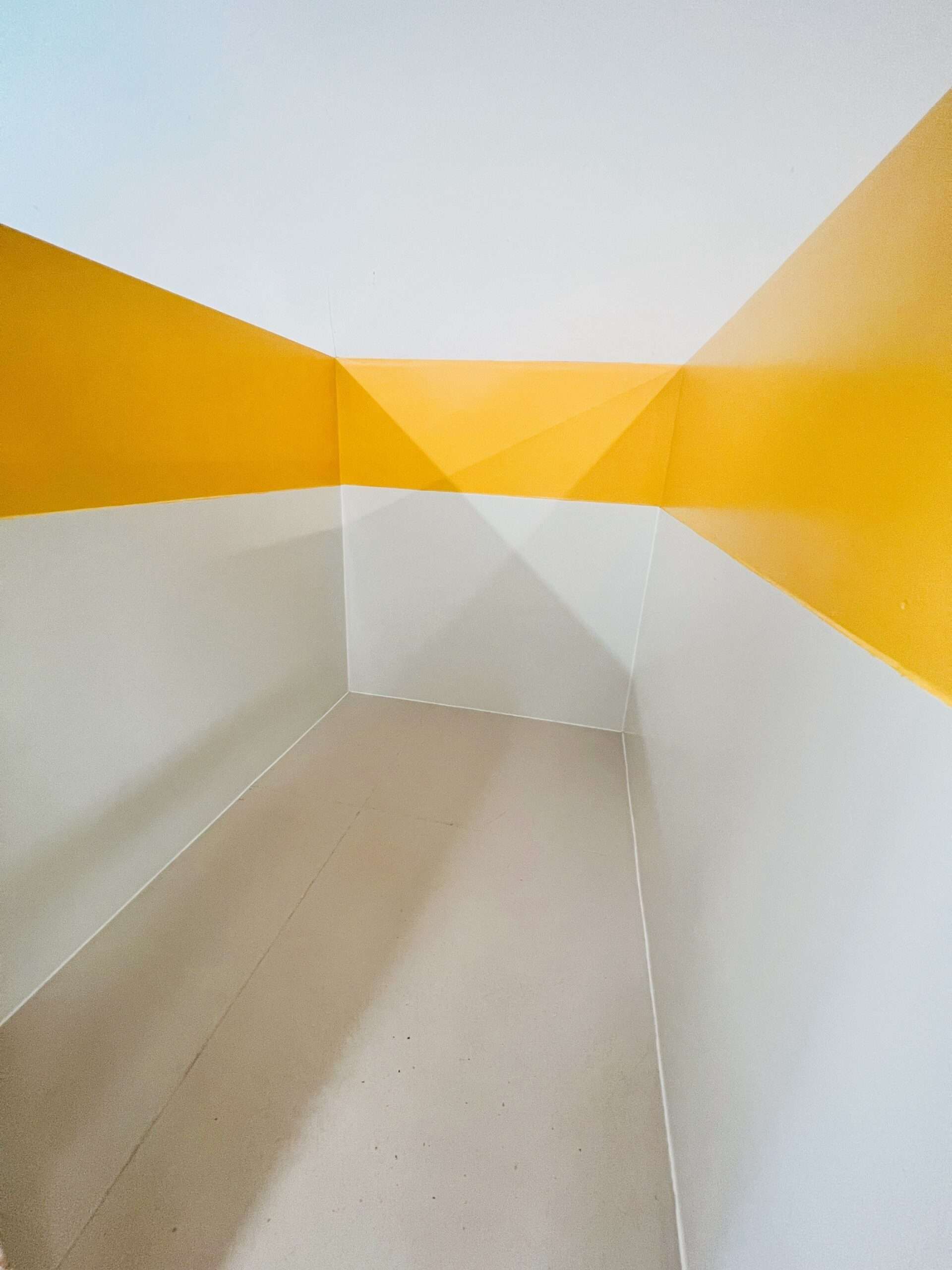 A white and yellow room with a curved wall.