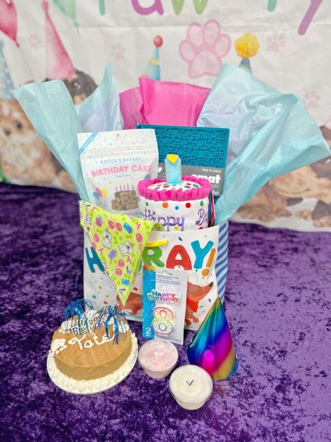 A birthday gift basket with candles and cake.