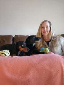 A woman sitting on the couch with two dogs.