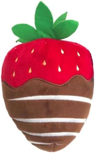 A stuffed strawberry is sitting on top of the floor.