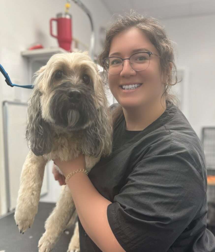 A woman holding a dog in her arms.